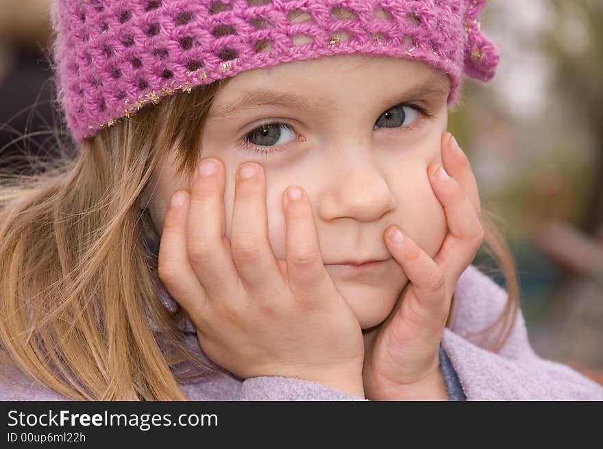 Little pretty thoughtful girl wearing a green hat. Little pretty thoughtful girl wearing a green hat