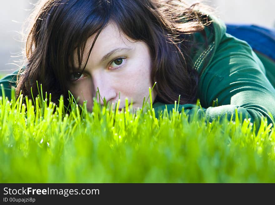 Young woman staring at camera in the grass. Young woman staring at camera in the grass.