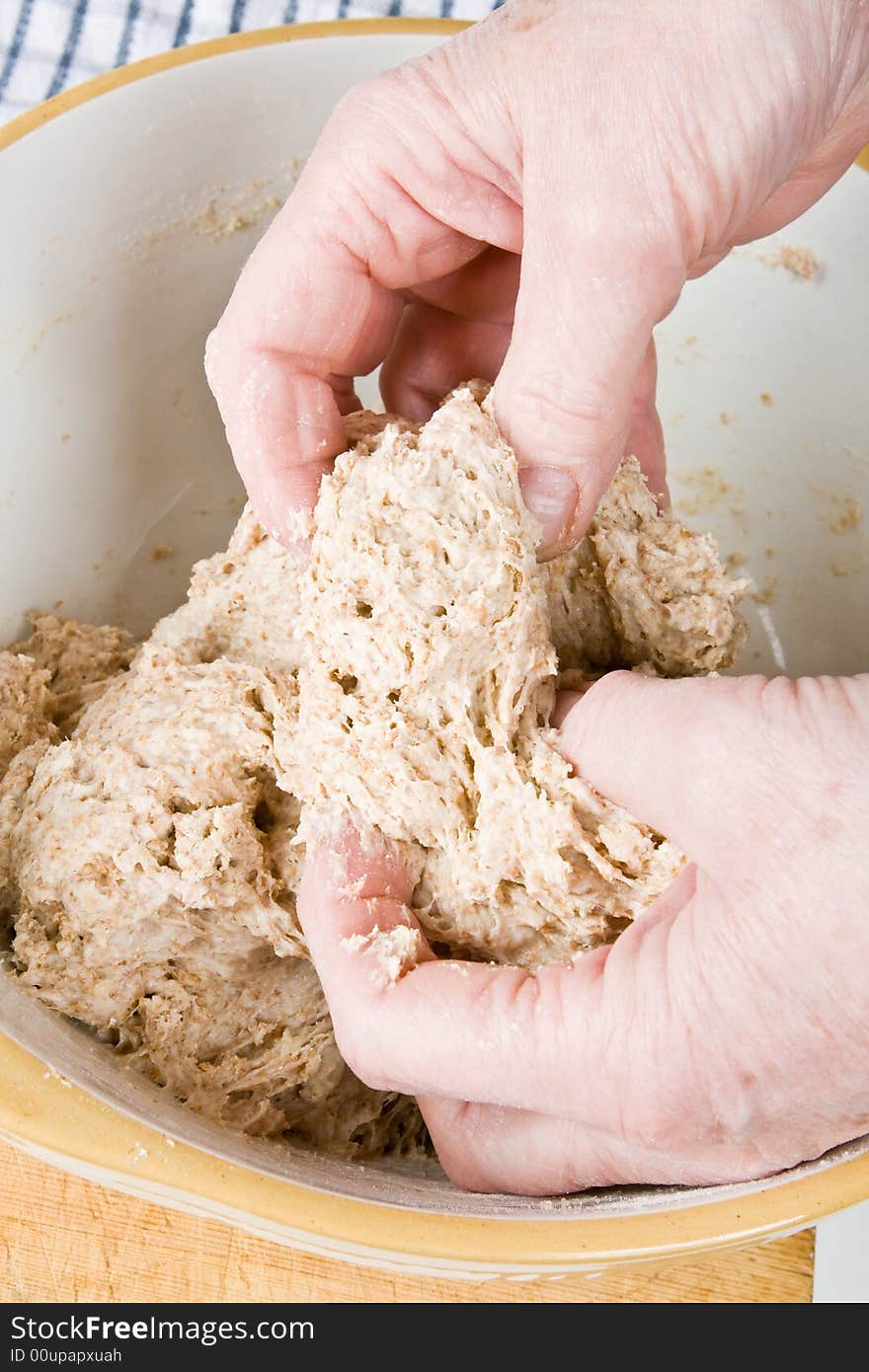 Hands mixing fresh dough in a bowl. Hands mixing fresh dough in a bowl