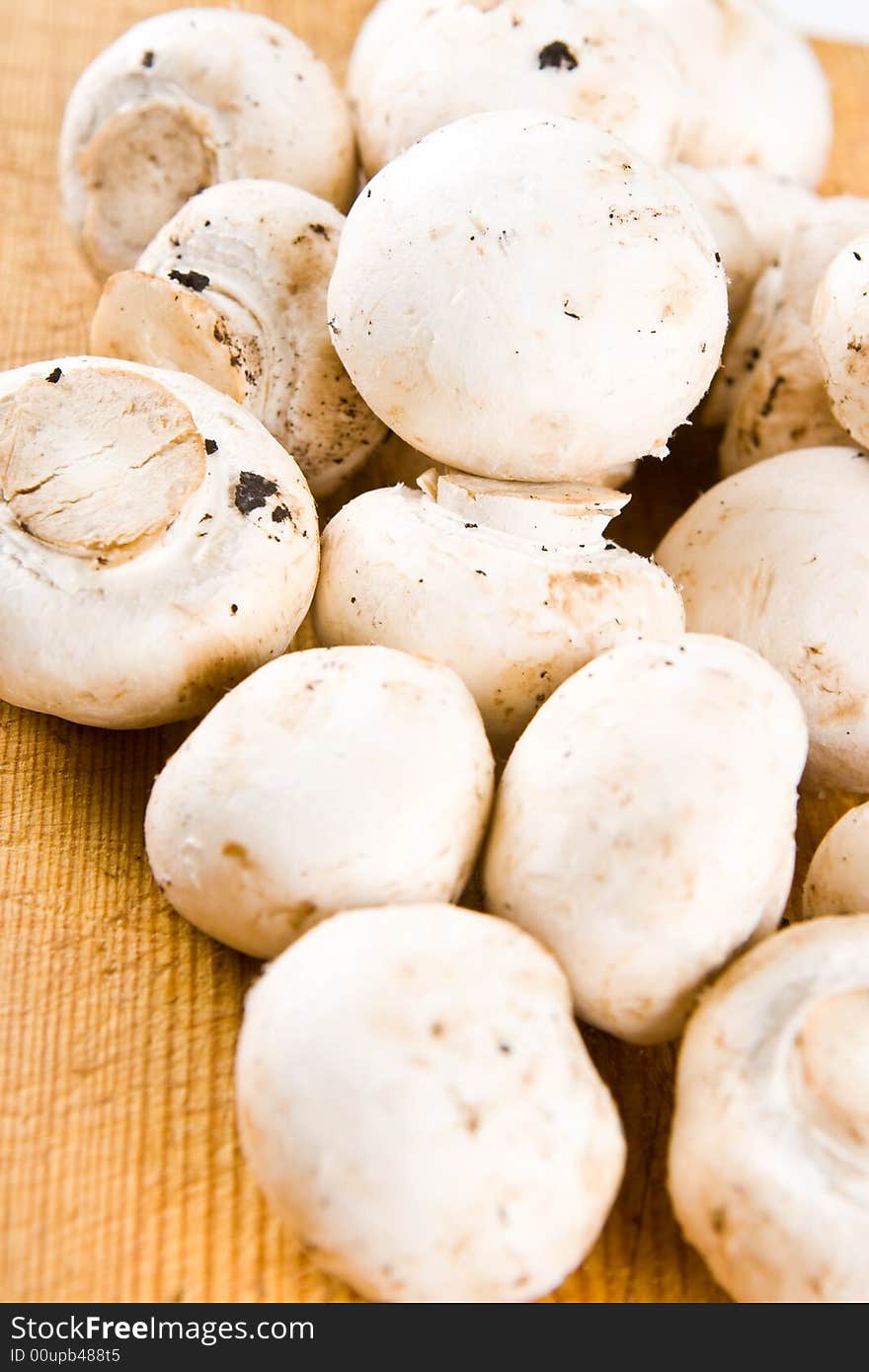 Uncut Mushrooms On A Wooden Board