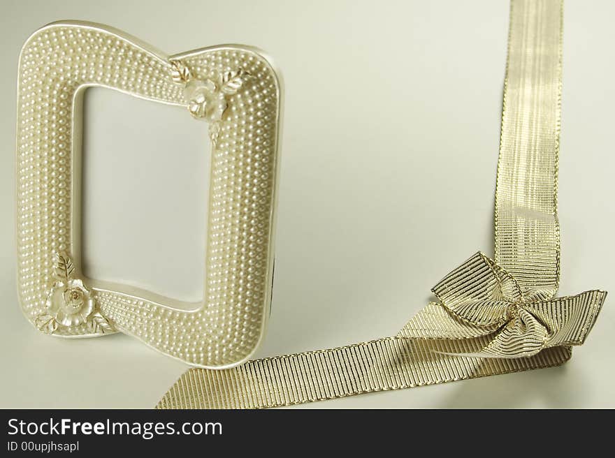 Golden ribbon and bow with a pearl picture frame. Golden ribbon and bow with a pearl picture frame