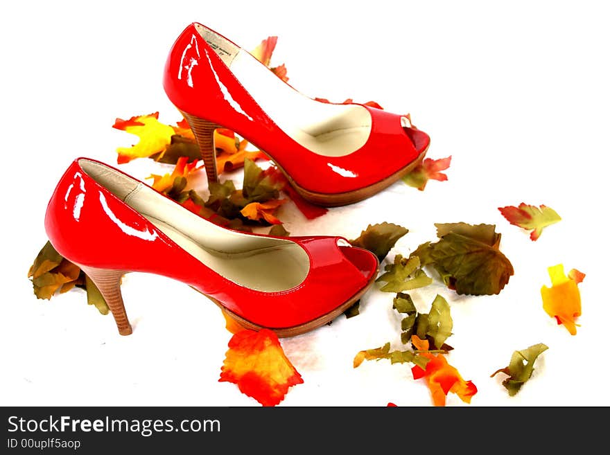 A pair of red high heel pumps on soft satiny white cloth. A pair of red high heel pumps on soft satiny white cloth.