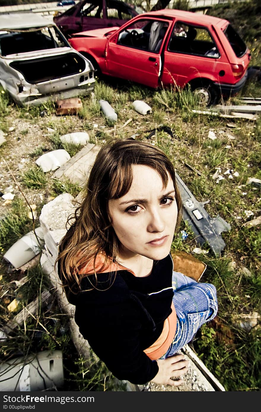 Young woman in the scrapyard, wide angle