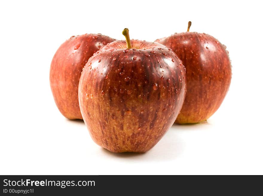 Three red apples with waterdrops isolated on white