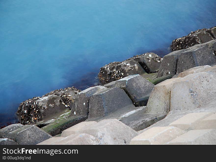 A manmade bulwark with oyster and blue sea