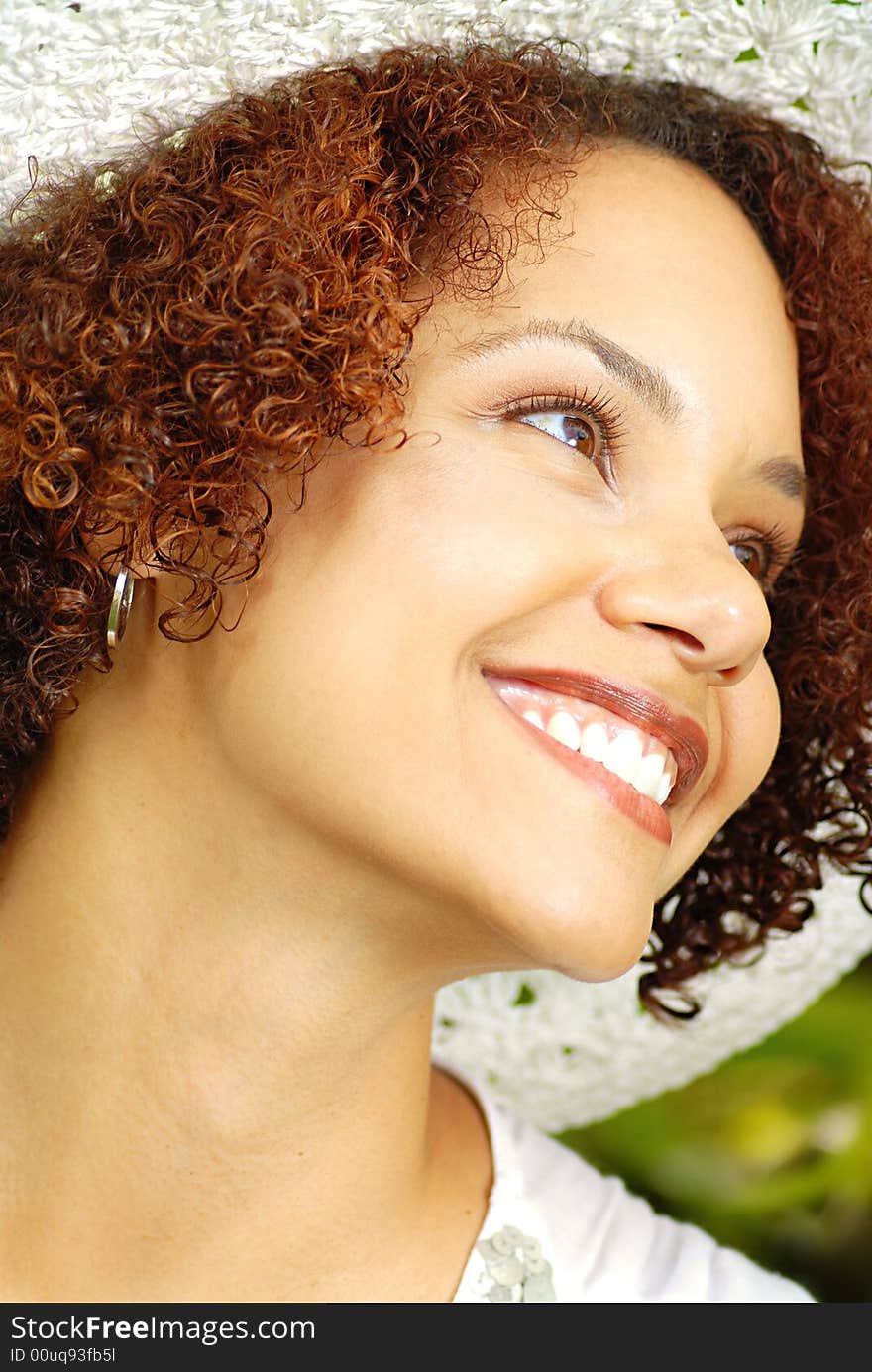 Beautiful young woman in a summer hat laughing outdoors. Beautiful young woman in a summer hat laughing outdoors