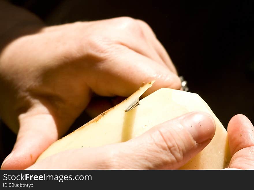 A women peeling a potato close up of the womens hands