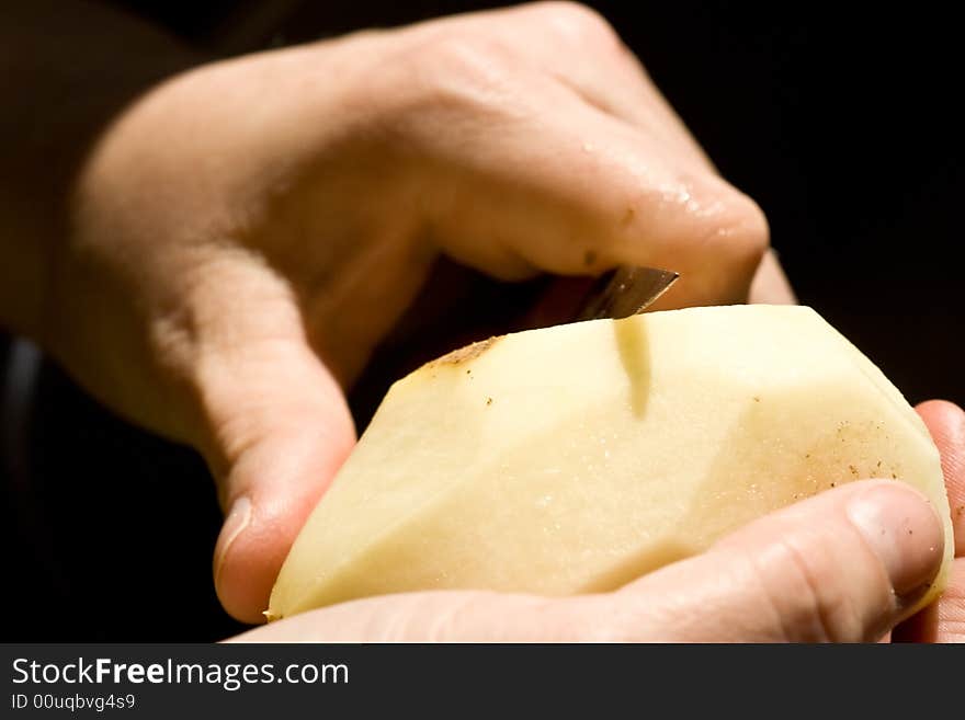 A women peeling a potato close up of the womens hands