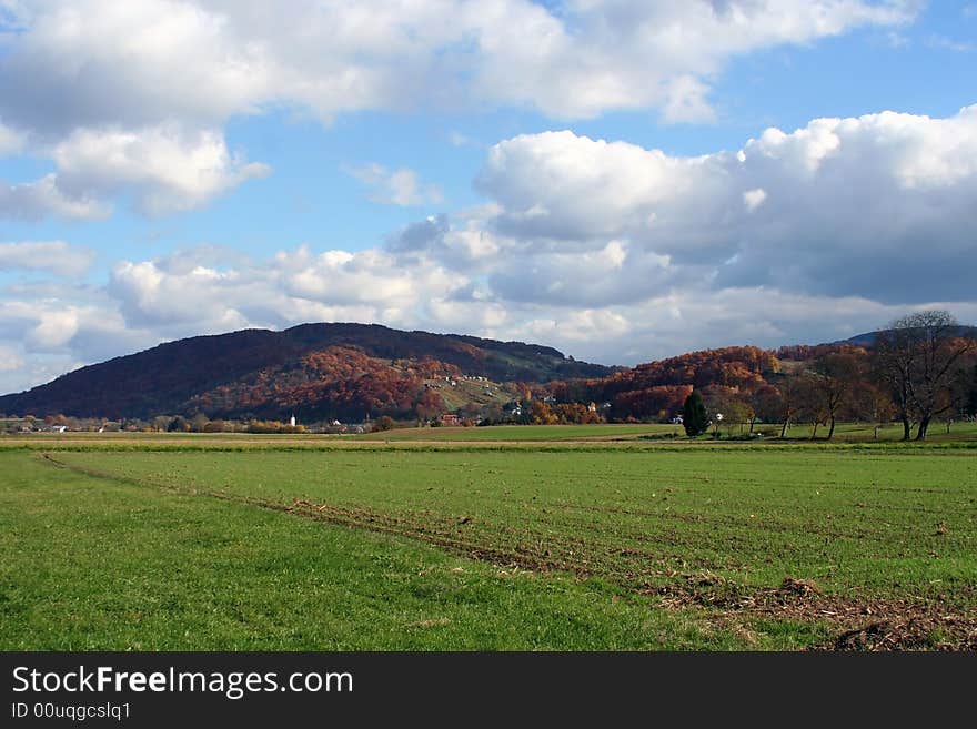 Landscape with some hills and clouds in the background.