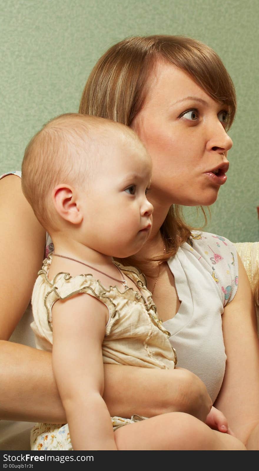 Mother with the kid are strongly surprised and look aside from the camera. Mother with the kid are strongly surprised and look aside from the camera