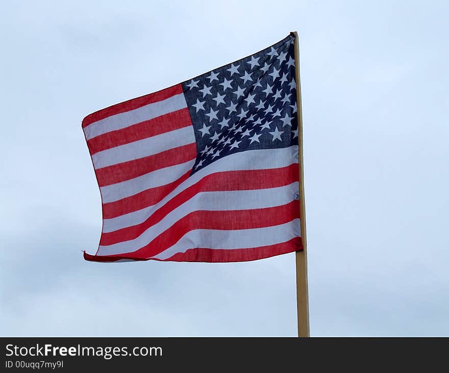 The flag of the USA on the background of the blue sky