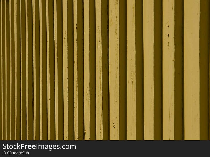 Detail of a mustard yellow wooden slatted wall. Detail of a mustard yellow wooden slatted wall