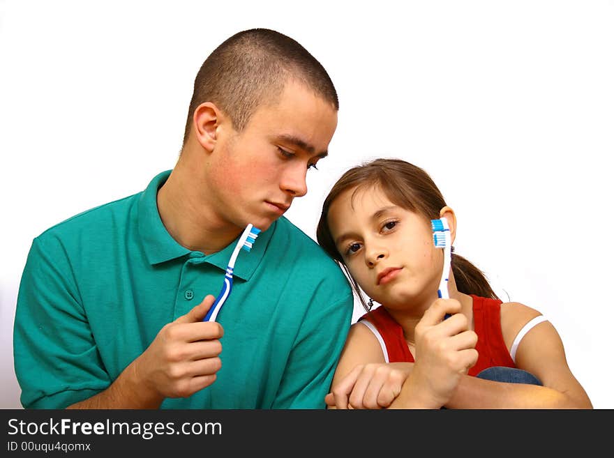 Brother and sister clean a teeth.