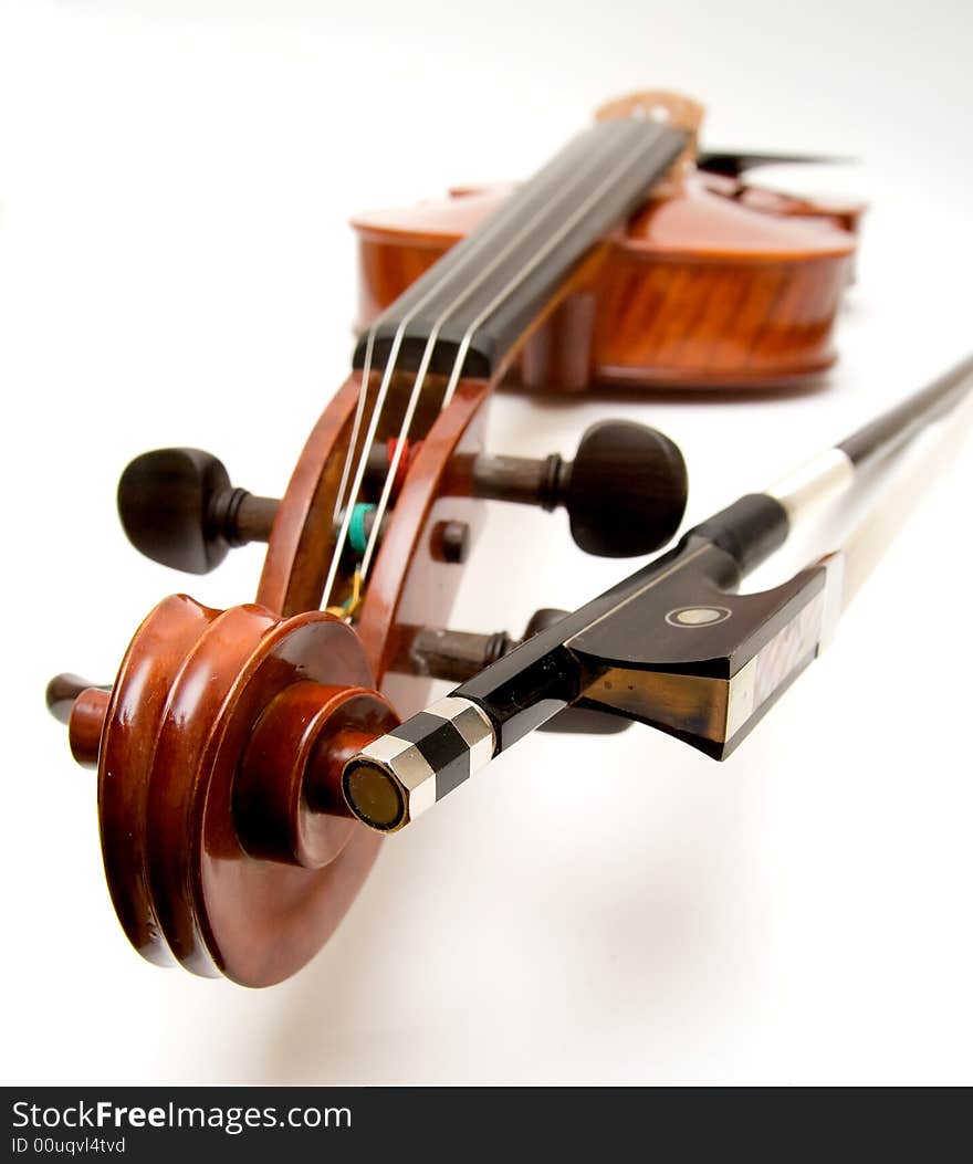 A violin and bow with the focus on the scroll and button of the bow.