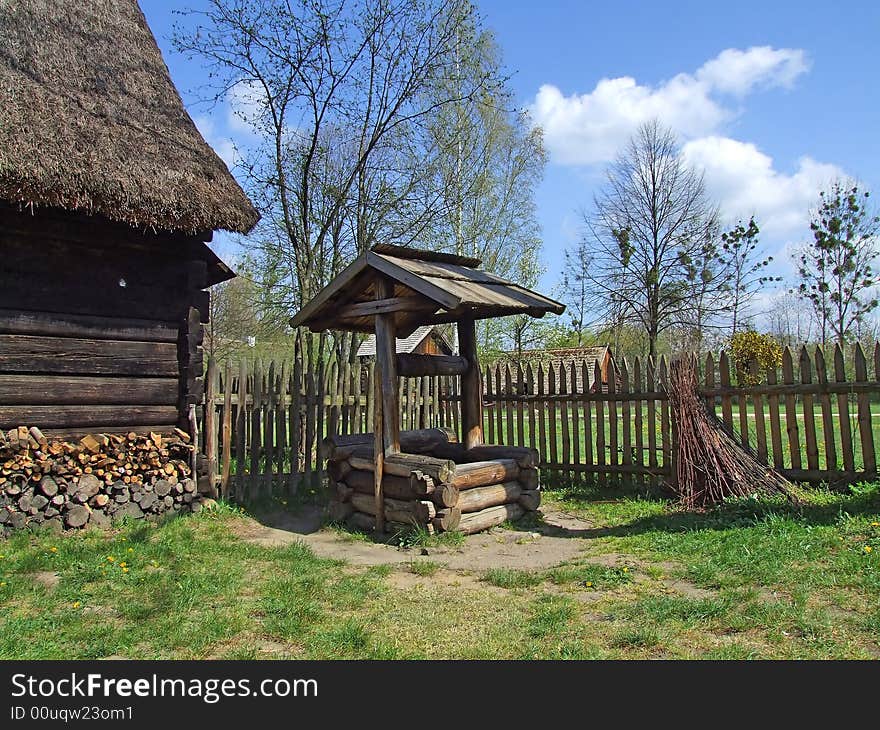 Old wooden hut in village, green grass around