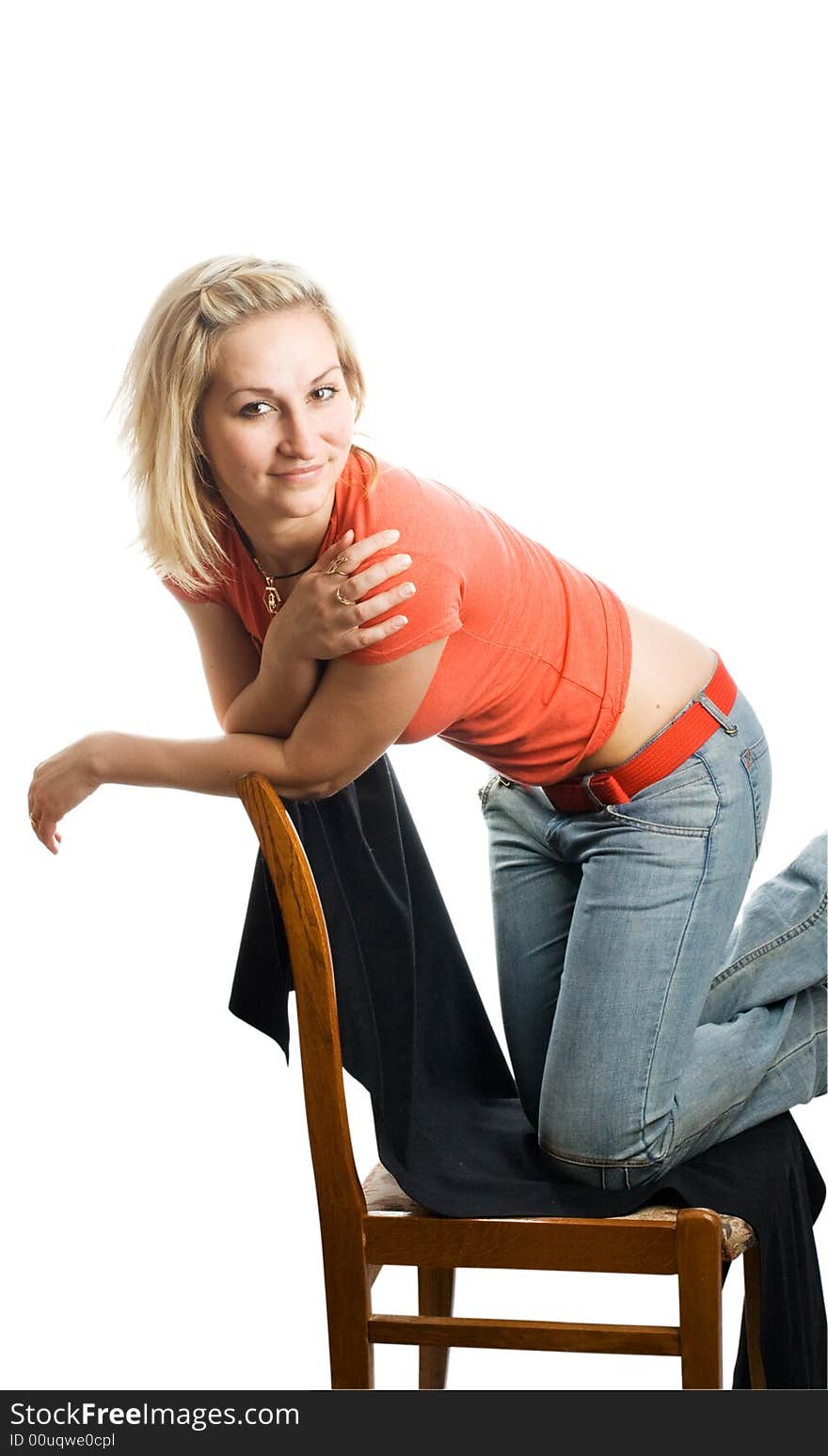 Girl in red t-shirt and blue jeans on the chair. Isolated.