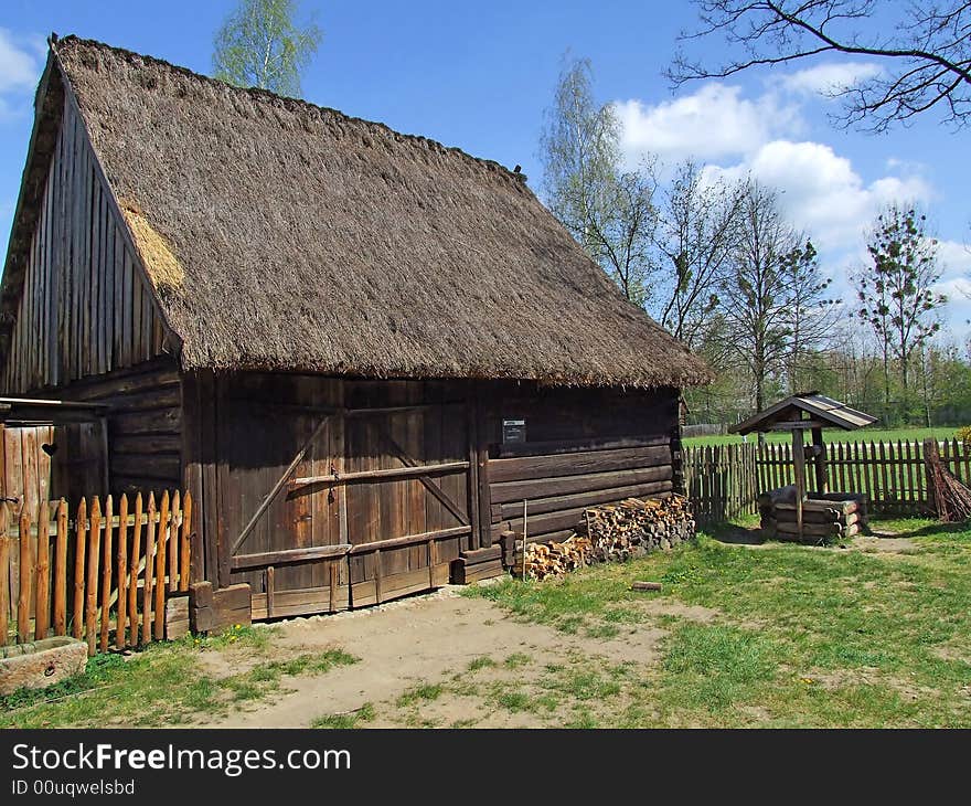 Old wooden hut in village, green grass around