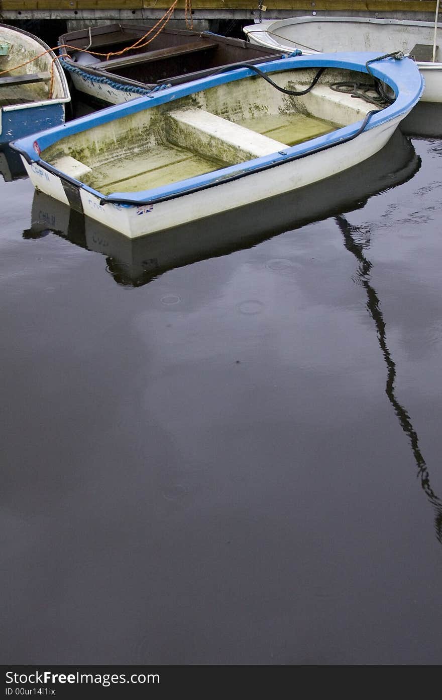 Blue dinghy rowing boat mored on the quayside in Lymington