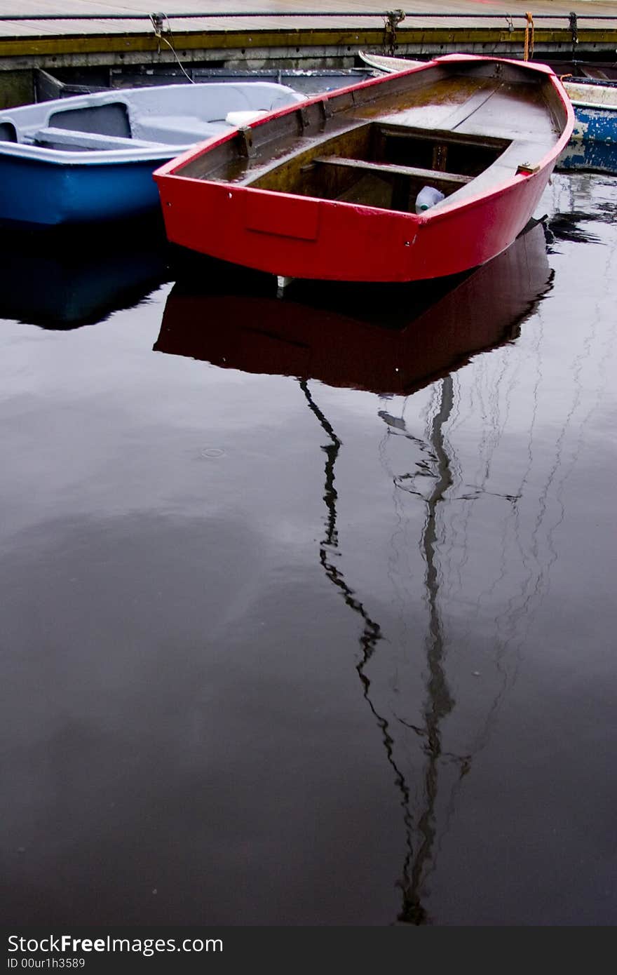 Red dinghy rowing boat mored on the quayside in Lymington