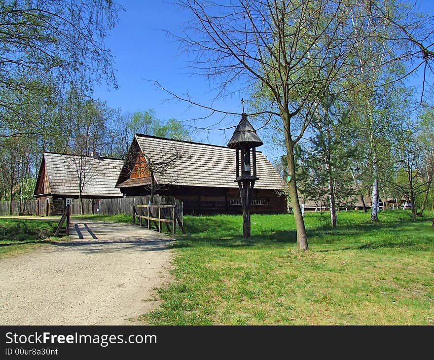 Old wooden hut in village, green grass around