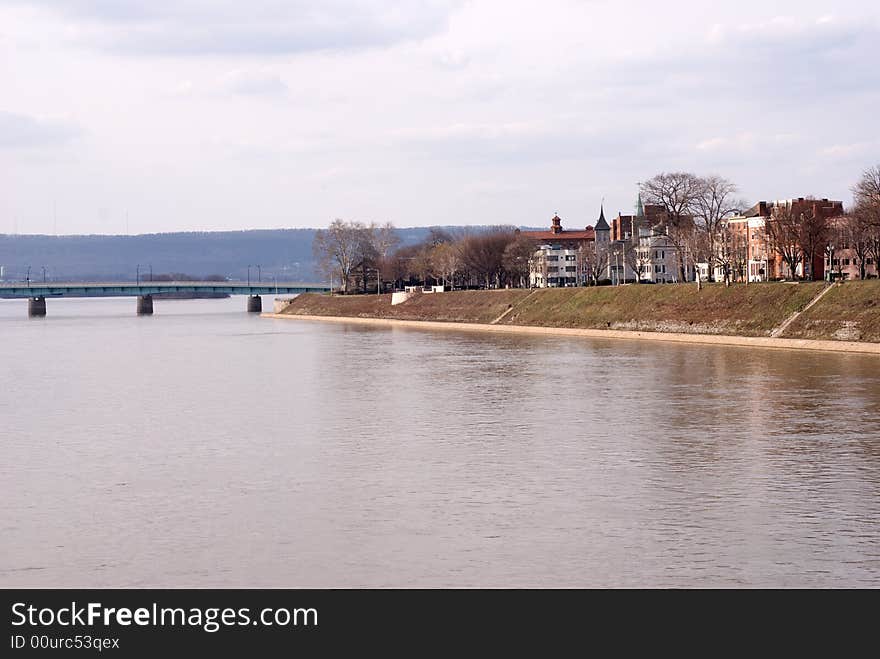 River front with bridge and concrete path along river.