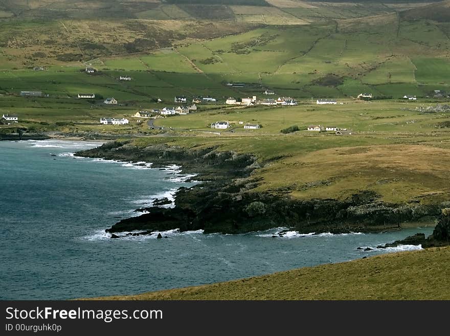 Rocky coastline with fields and mountains in Southern Ireland. Rocky coastline with fields and mountains in Southern Ireland