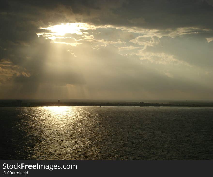 Island of Cozumel in Mexico. Clouds partially cover the sun. View from the water. Island of Cozumel in Mexico. Clouds partially cover the sun. View from the water.