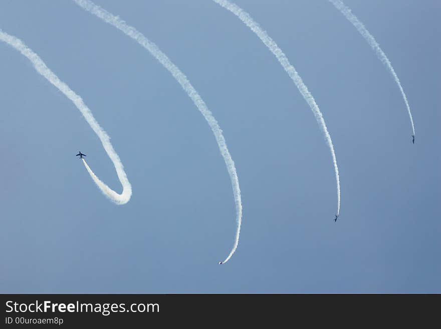 Four jets with white smoke traces in the blue sky. Four jets with white smoke traces in the blue sky.