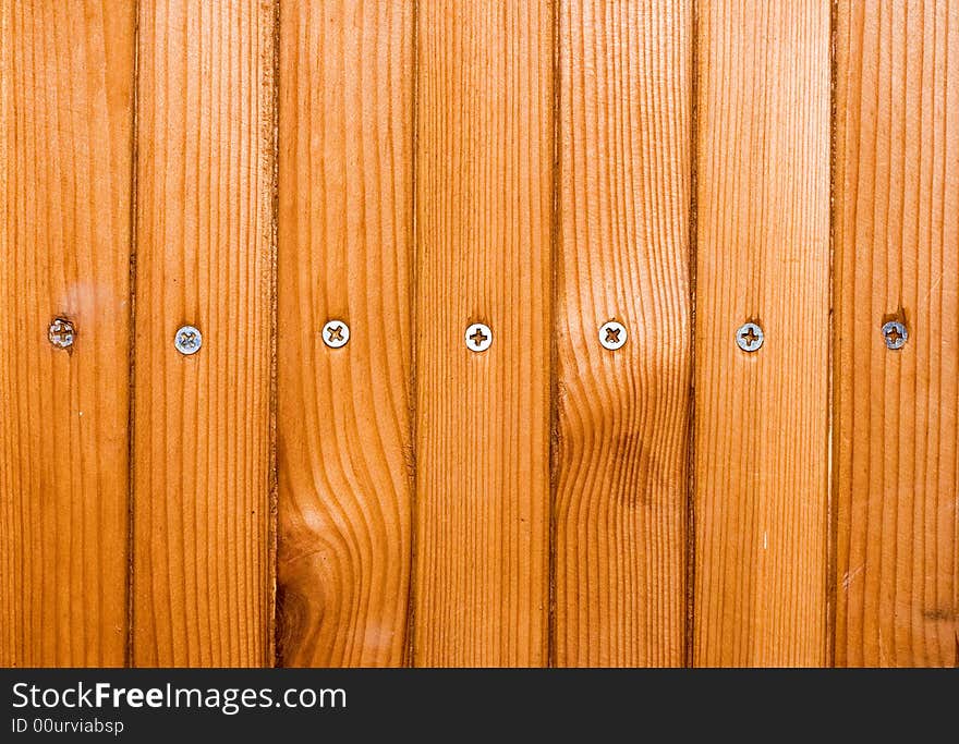 Brown planks with screw heads screwed in wooden wall. Brown planks with screw heads screwed in wooden wall.