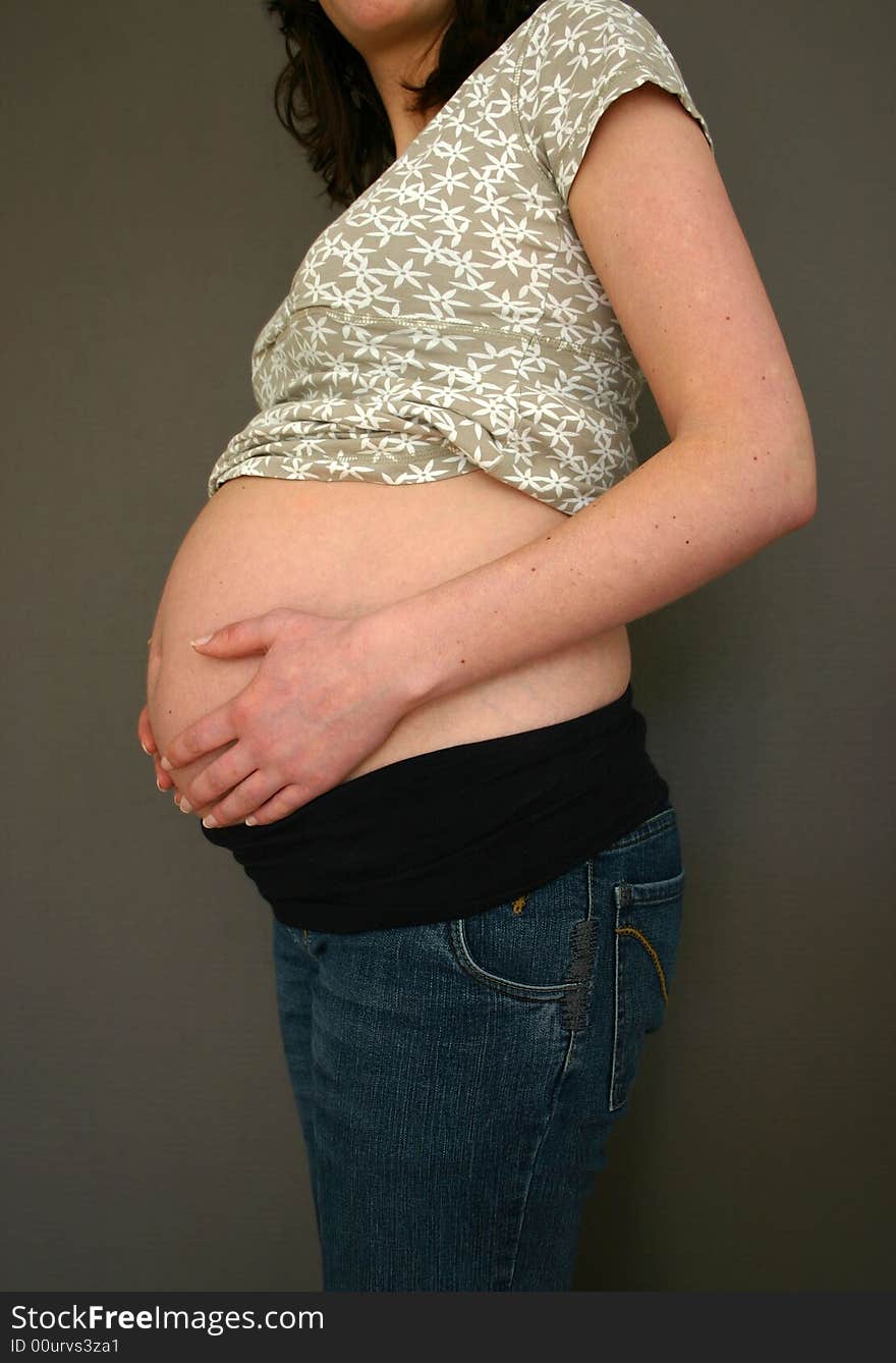 A pregnant woman is holding her belly