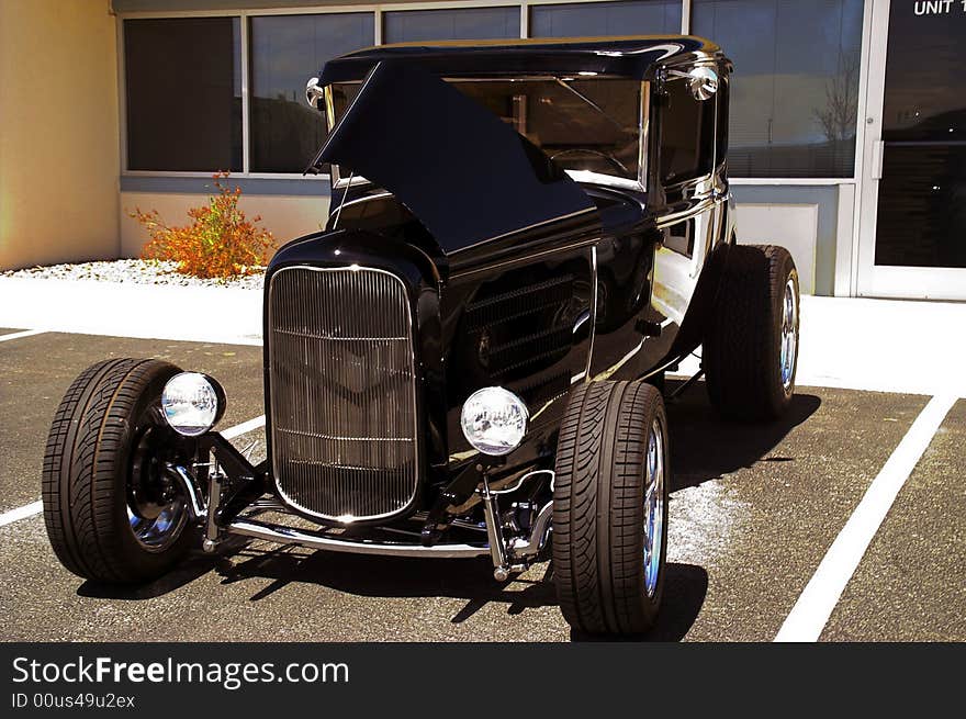 A classic black hotrod shines in the sunlight