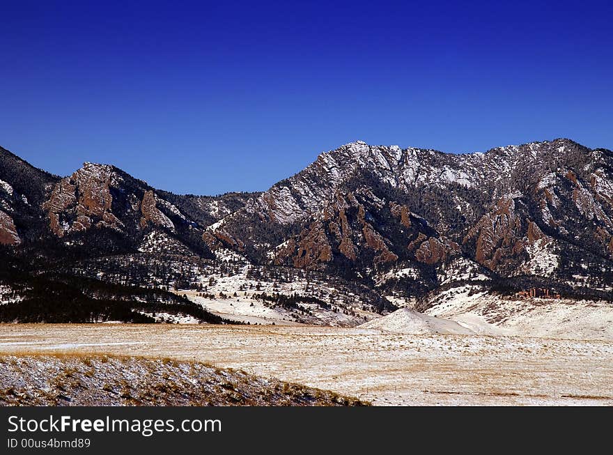 Boulder Colorado's  Flatiron Mountains against blue sky witha dusting of snow. Boulder Colorado's  Flatiron Mountains against blue sky witha dusting of snow