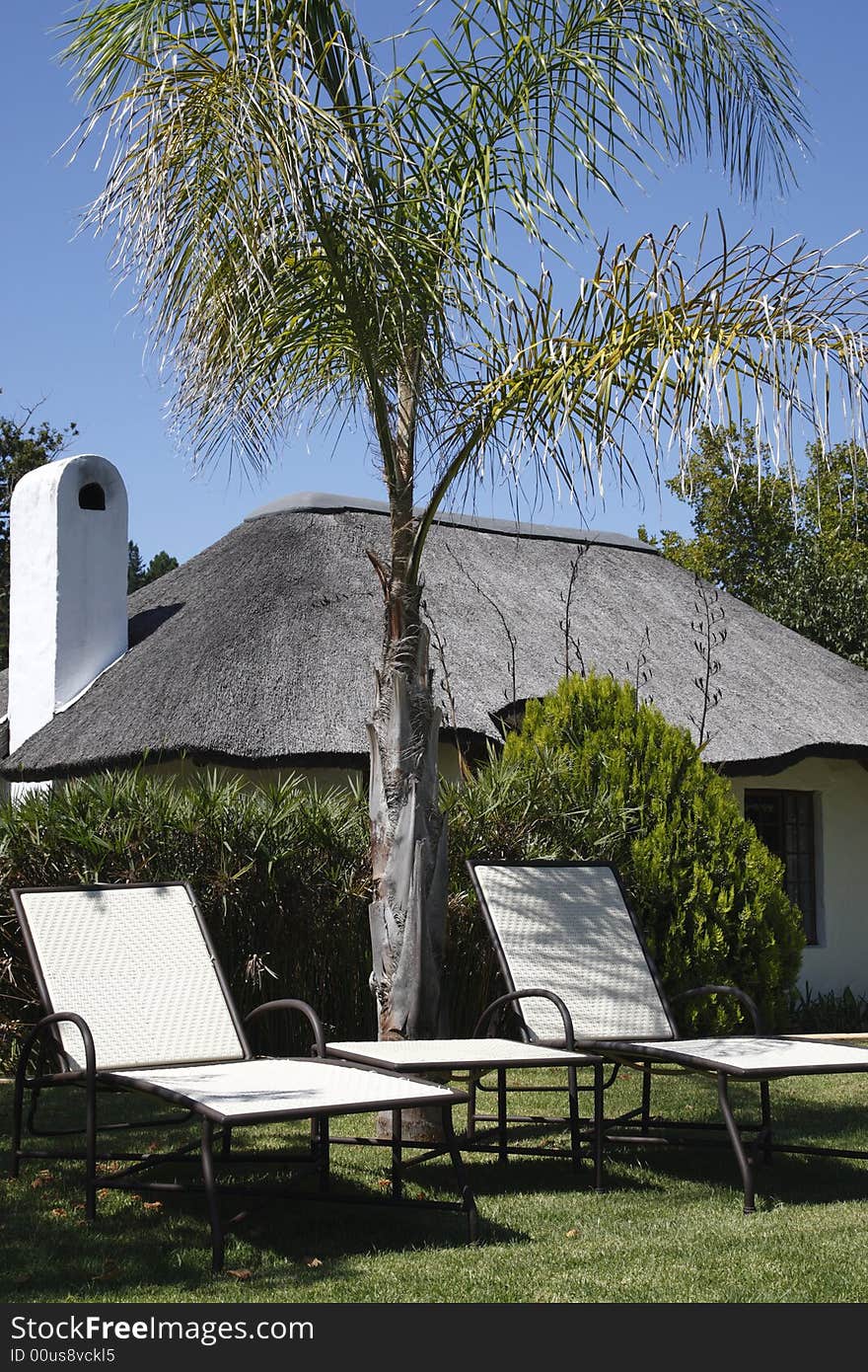 Empty sun loungers outside a small thatched house knysna western cape province south africa