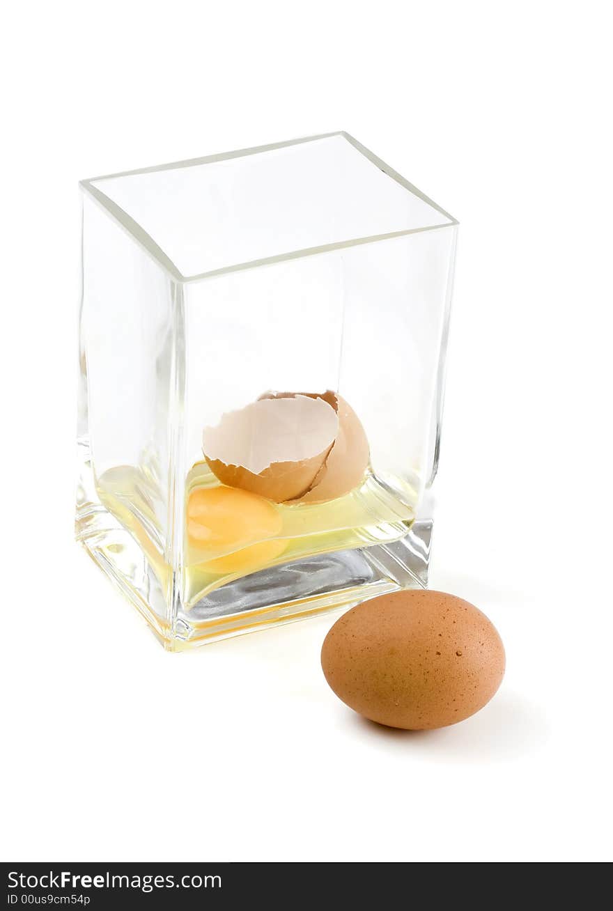 Cracked chicken egg with the yolk in a glass vase. Cracked chicken egg with the yolk in a glass vase