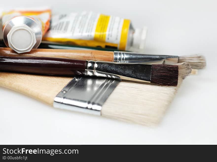 Different sizes of paint brushes with paint tubes