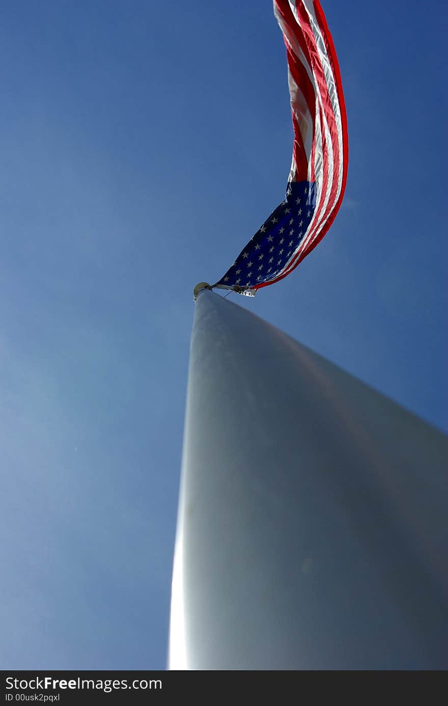 A unique view of a large American flag flying from the top of an aluminim flagpole. A unique view of a large American flag flying from the top of an aluminim flagpole.