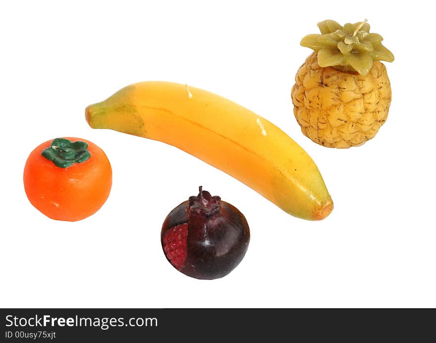 Four candles in the form of fruit a banana a pomegranate pineapple a persimmon