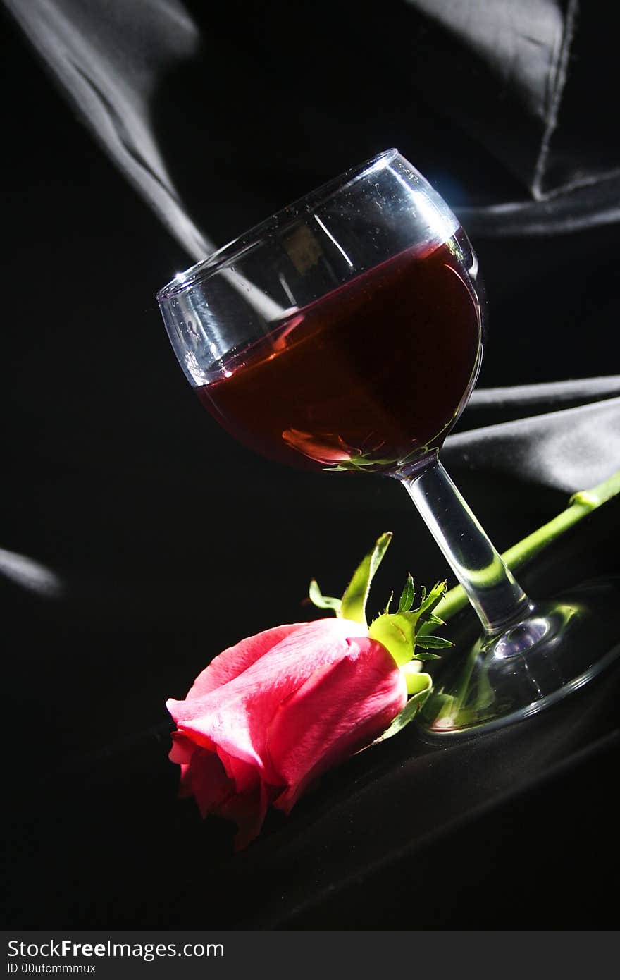 Red wine and rose on black background. Red wine and rose on black background