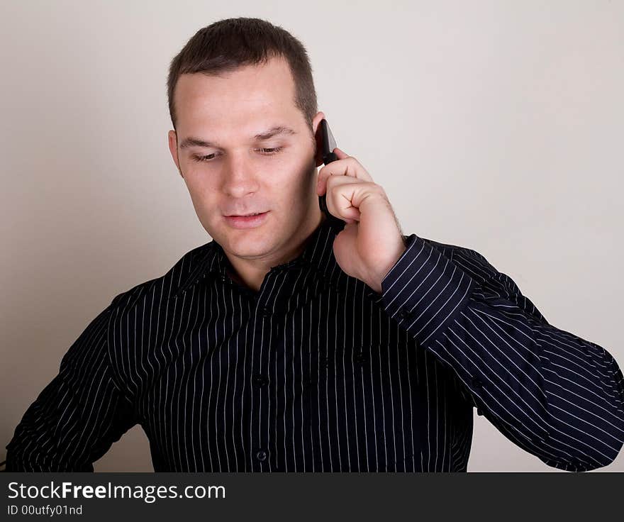 Young businessman talking on a mobile phone. Young businessman talking on a mobile phone