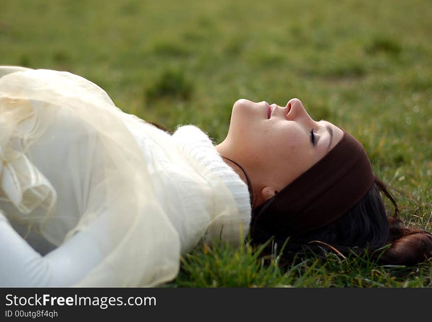 Attractive brunette woman lying on grass. Attractive brunette woman lying on grass