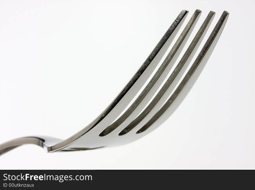 A closeup of a fork on white background