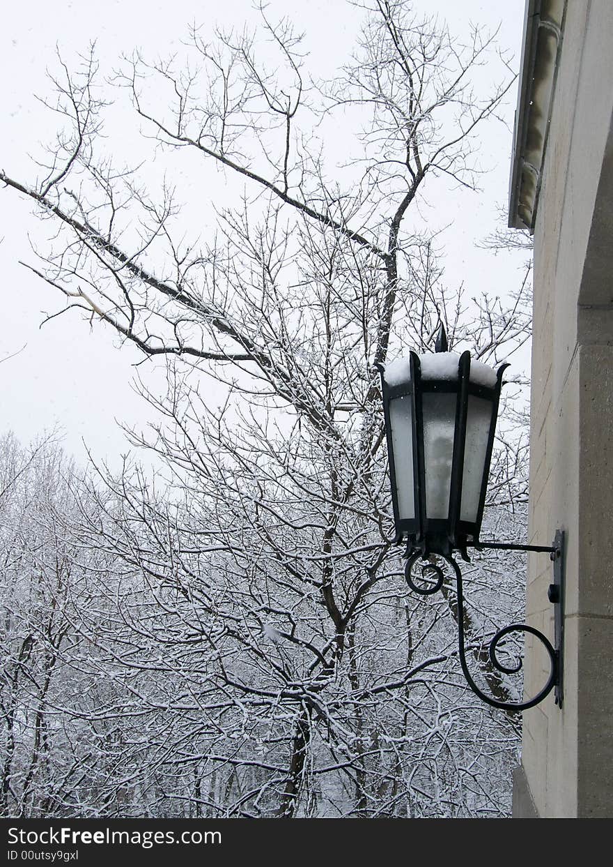 Exterior wall lamp collecting snow as snow falls. Exterior wall lamp collecting snow as snow falls