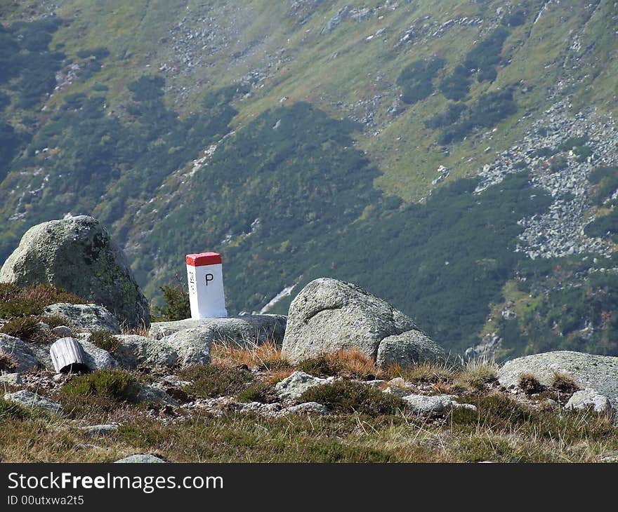 View on the slope of the another mountain. There is frontier pole and stones on first plan. View on the slope of the another mountain. There is frontier pole and stones on first plan