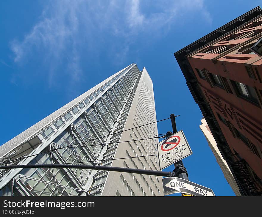 Contrast between an old stone and brick building and a gleaming steel, glass and concrete skyscraper in New York City. Contrast between an old stone and brick building and a gleaming steel, glass and concrete skyscraper in New York City