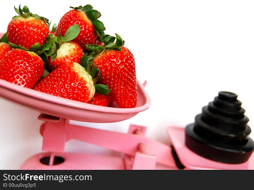 Strawberries in pink weighing scales. Strawberries in pink weighing scales