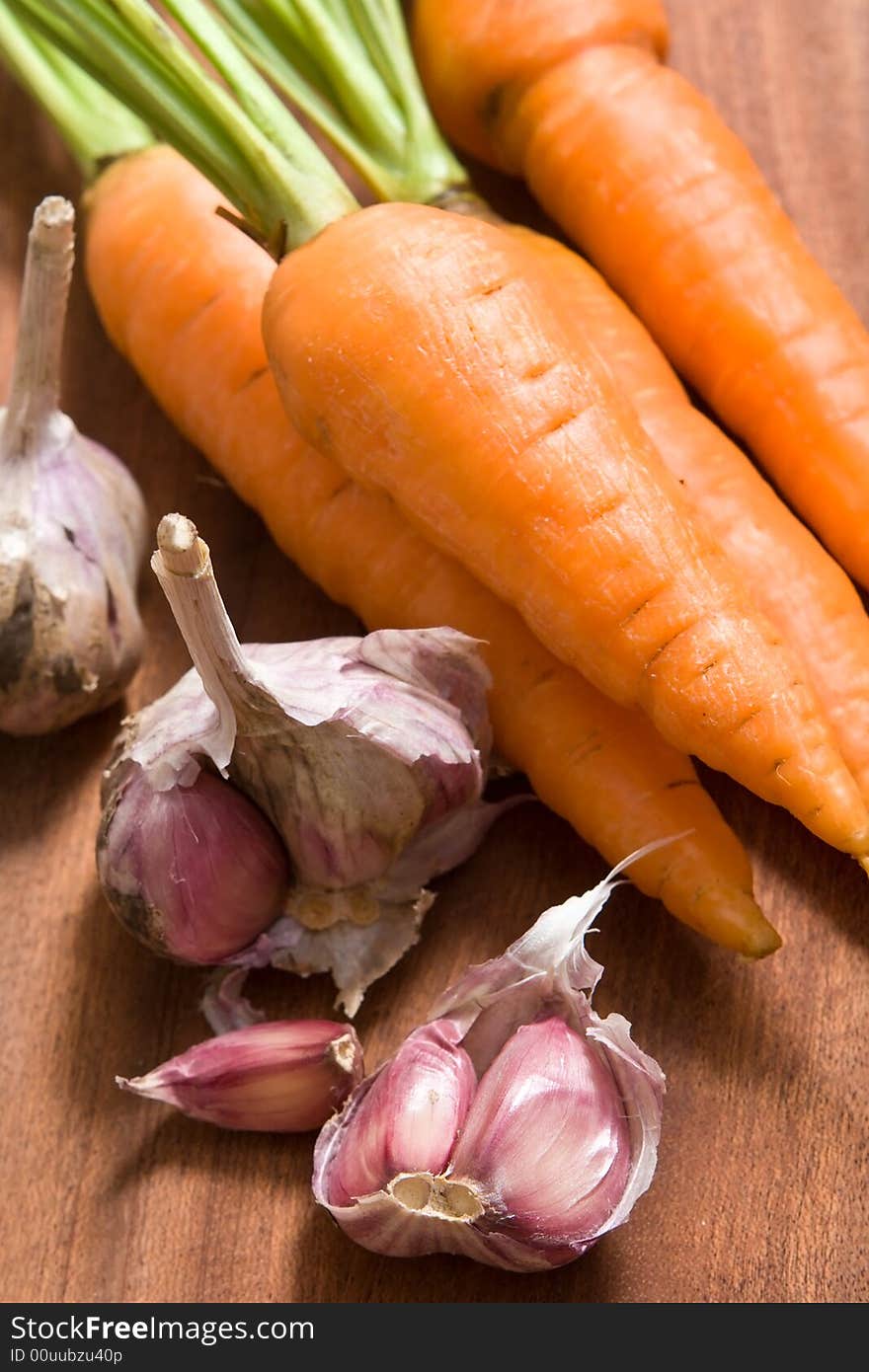 Fresh garlic and carrot on cutting board