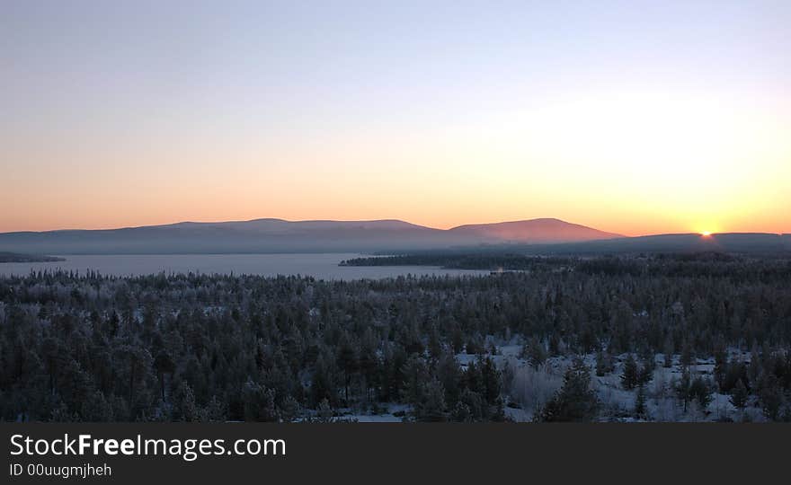 Sunrise in the winter morning above lake among mountains of Scandinavian peninsula. Sunrise in the winter morning above lake among mountains of Scandinavian peninsula