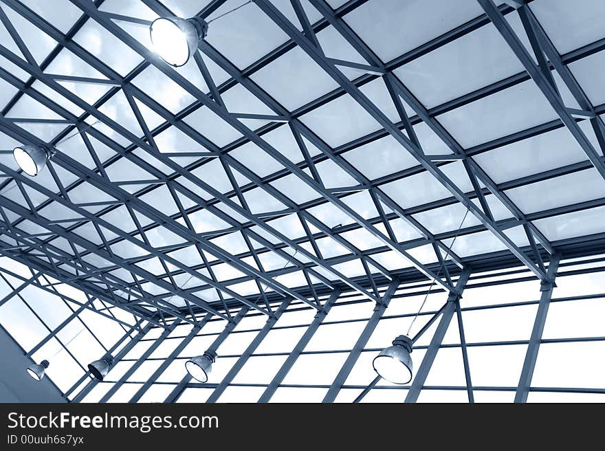 Steel ceiling with windows and lamps in a modern business center (toned blue). Steel ceiling with windows and lamps in a modern business center (toned blue)