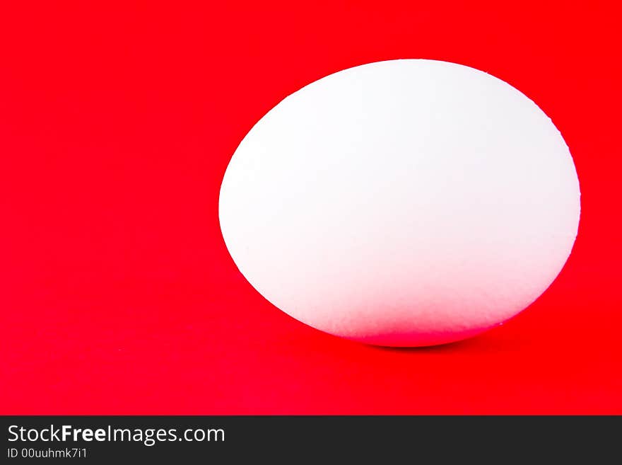 White egg on a red background