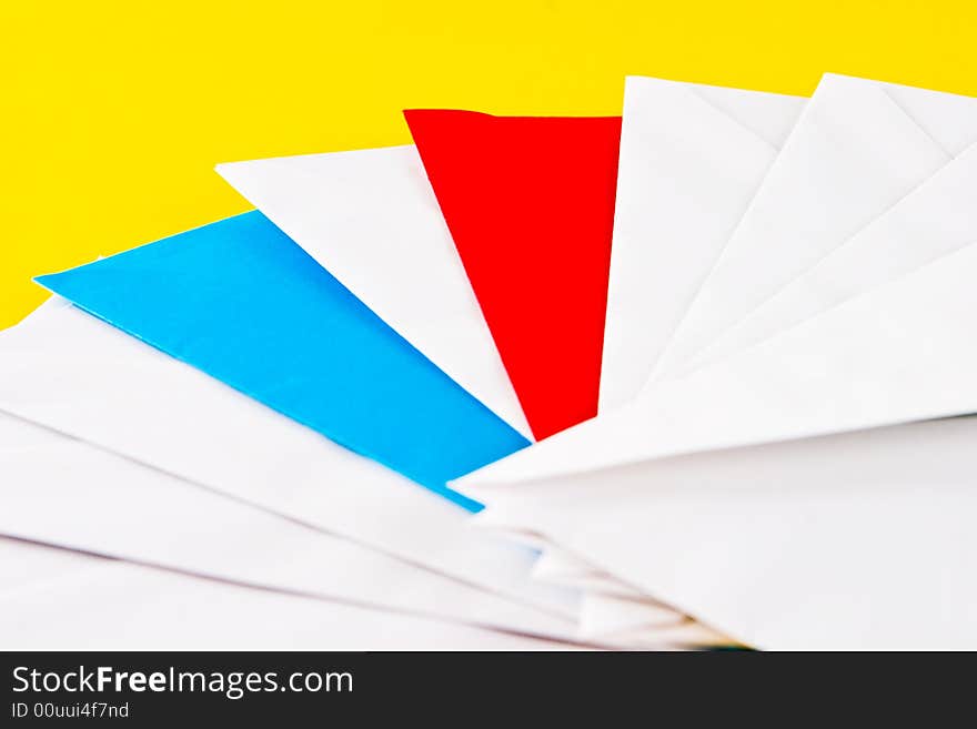 One red, one blue  and eight white envelopes on a yellow background. One red, one blue  and eight white envelopes on a yellow background